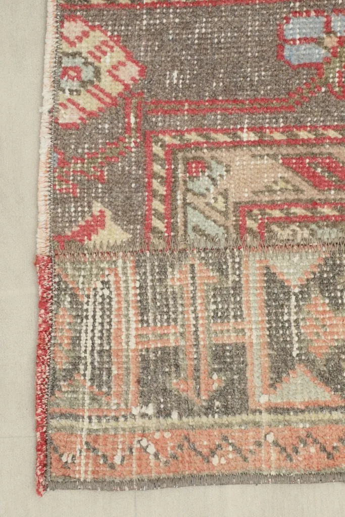 Close-up of the rug's end, showing border patterns and some wear on the edge