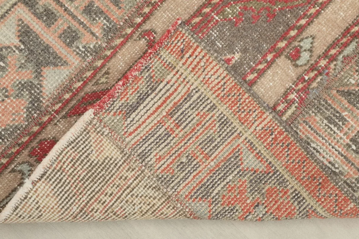 View of the back of the hand-knotted wool rug, revealing its cotton foundation