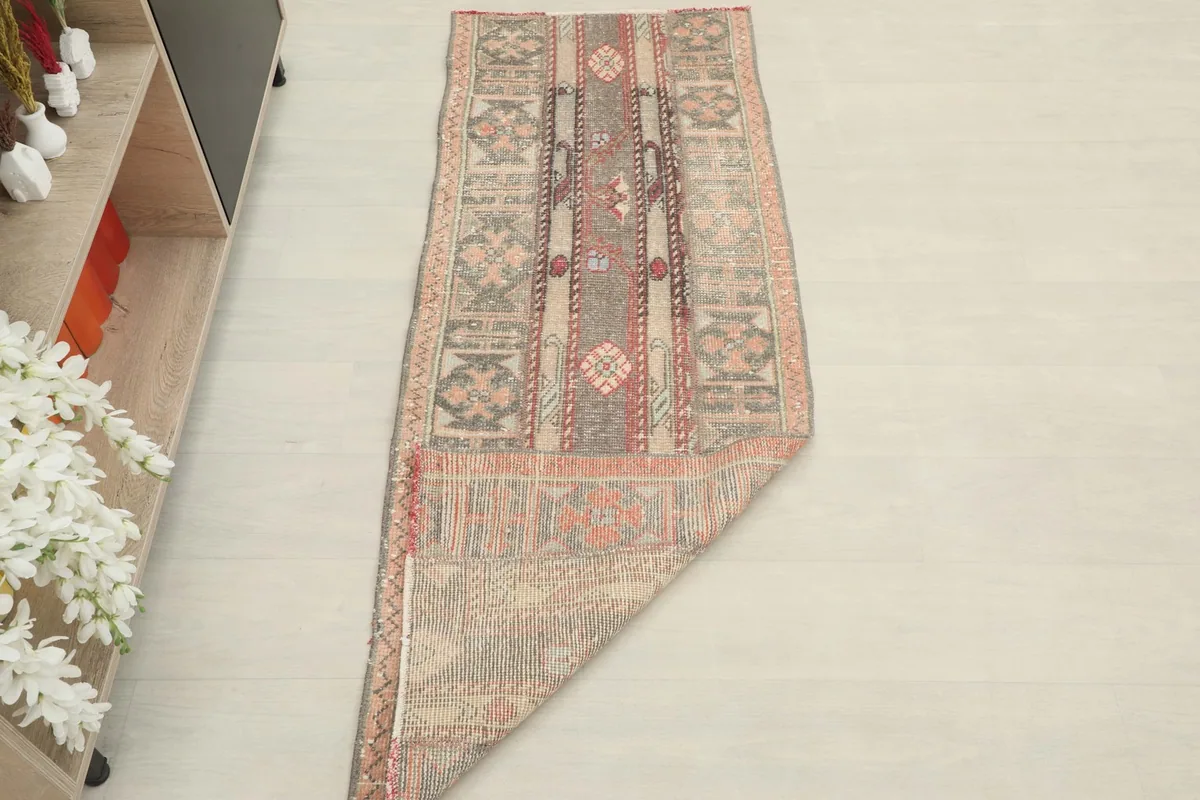 Angled view of the runner rug with one end folded, showcasing its texture and colors