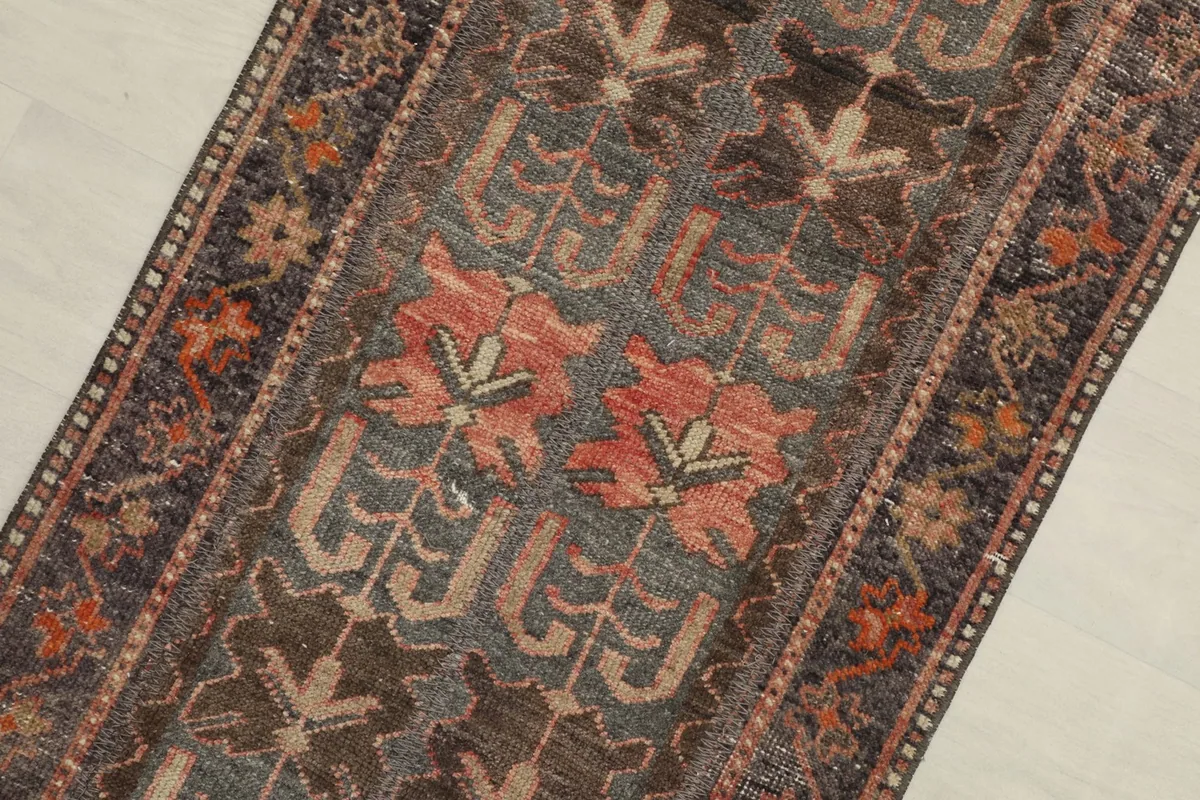 Close-up detail of the tribal motifs and colors on the vintage wool rug