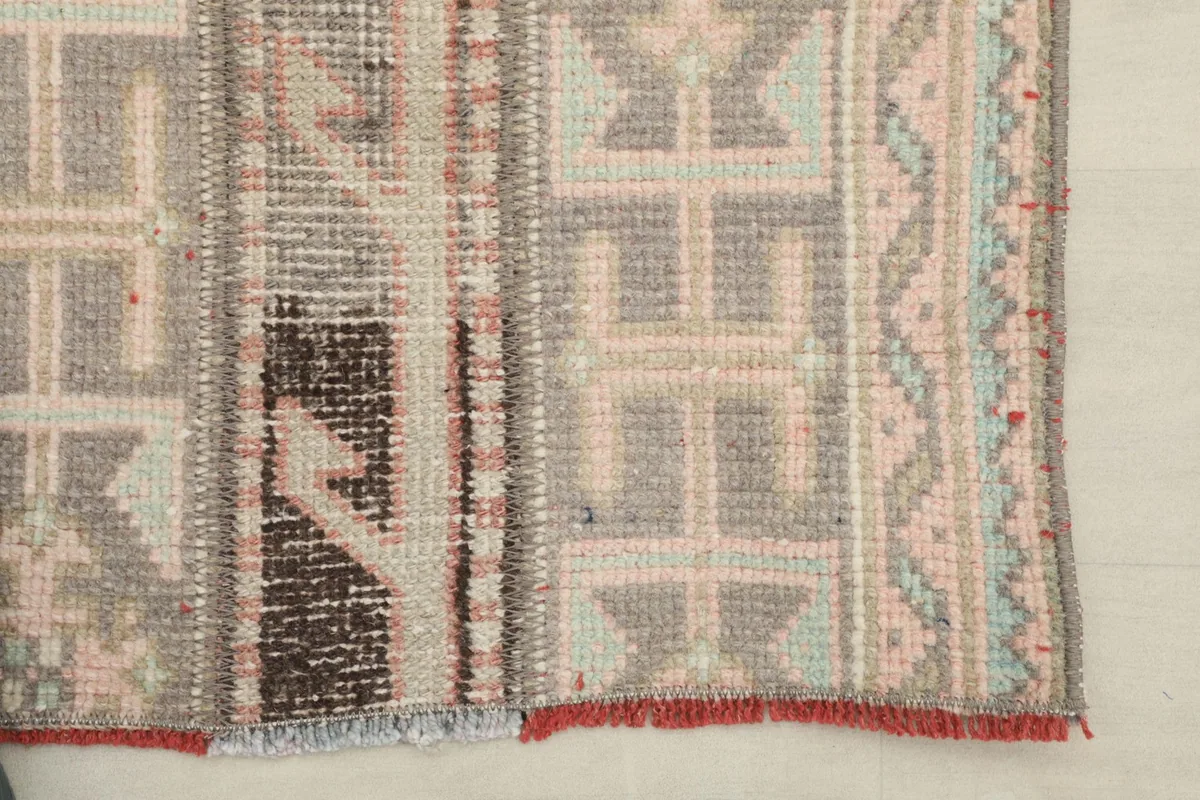 Close-up of the rug's edge, showing the intricate geometric patterns and fringe detail