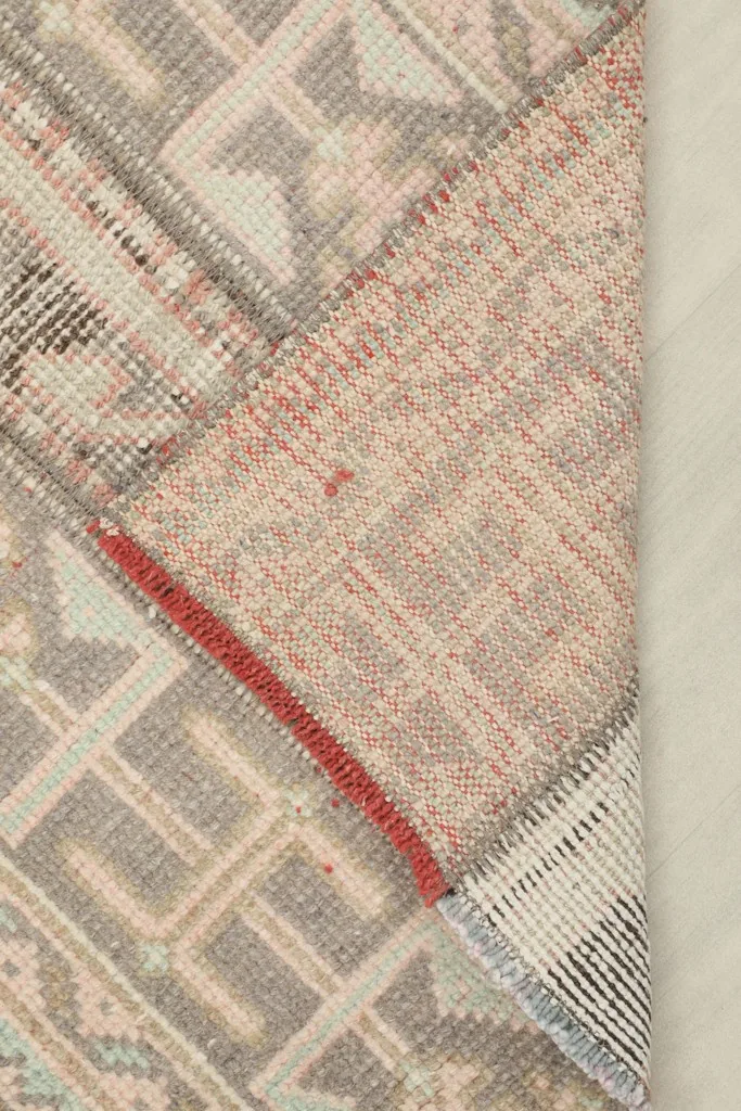View of the back of the hand-knotted wool runner, revealing its cotton foundation