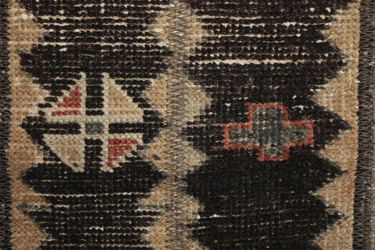 Detailed view of the intricate tribal motifs and color variations in the rug's pile