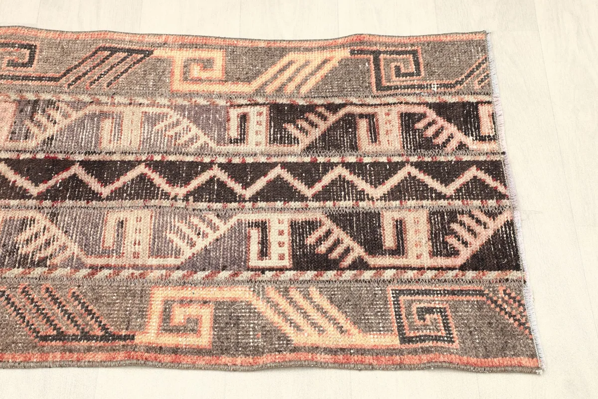Another angled view, focusing on the rug's distinct tribal designs and faded colors.