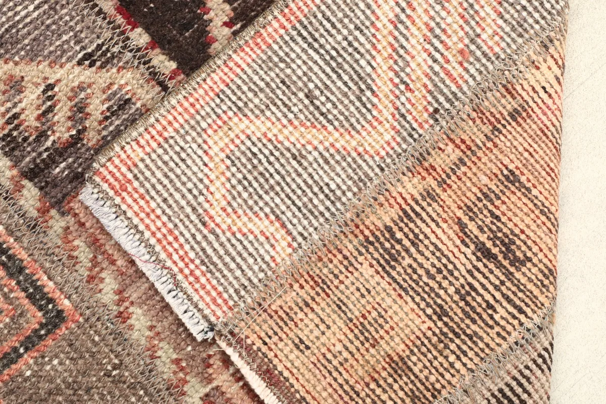 View of the rug's underside, revealing the hand-knotted cotton foundation and wool knots.