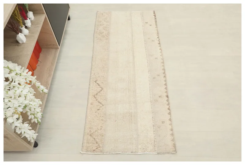 Full top view of the beige and tan patchwork vintage area rug