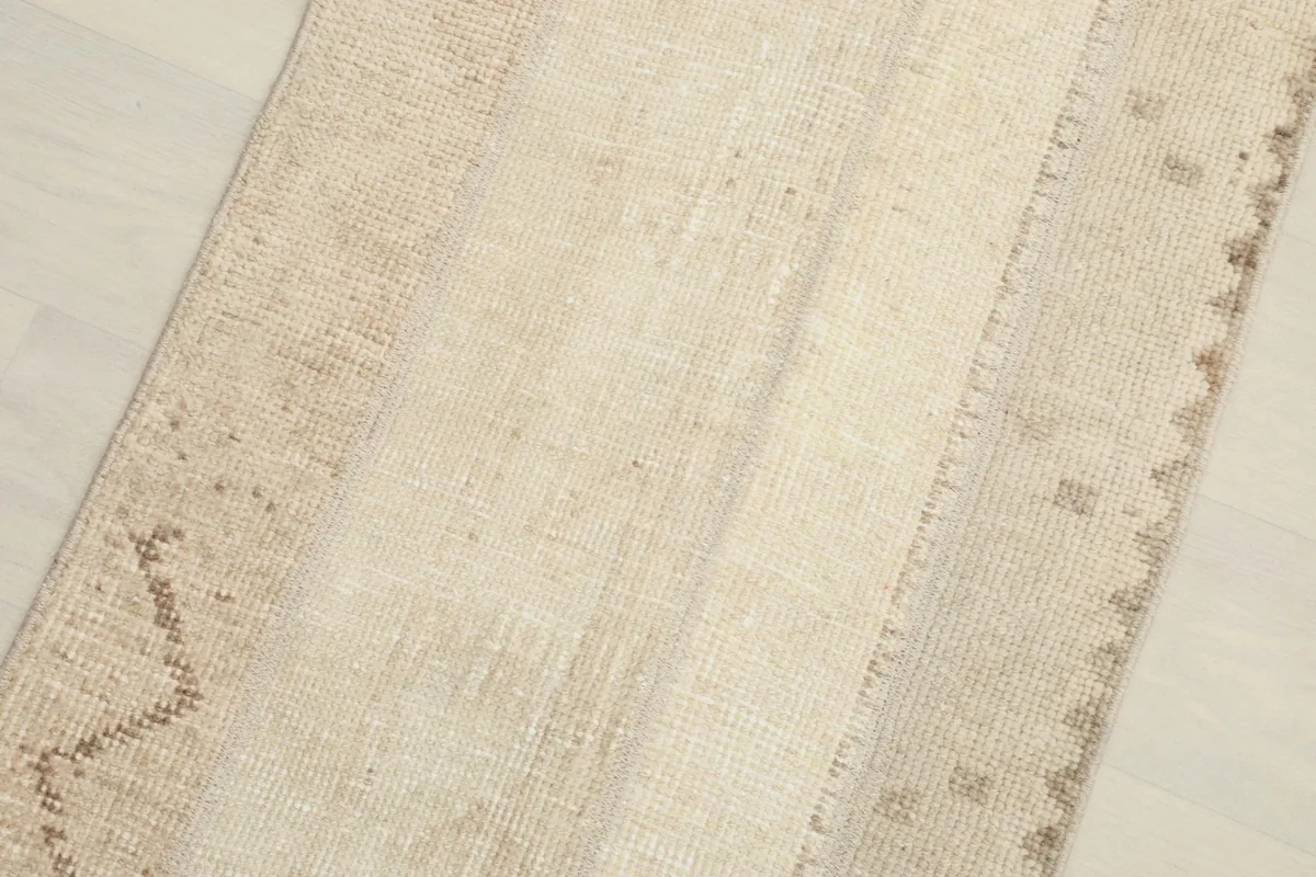 Close-up detail of the varied beige and tan tones and subtle patterns in the rug