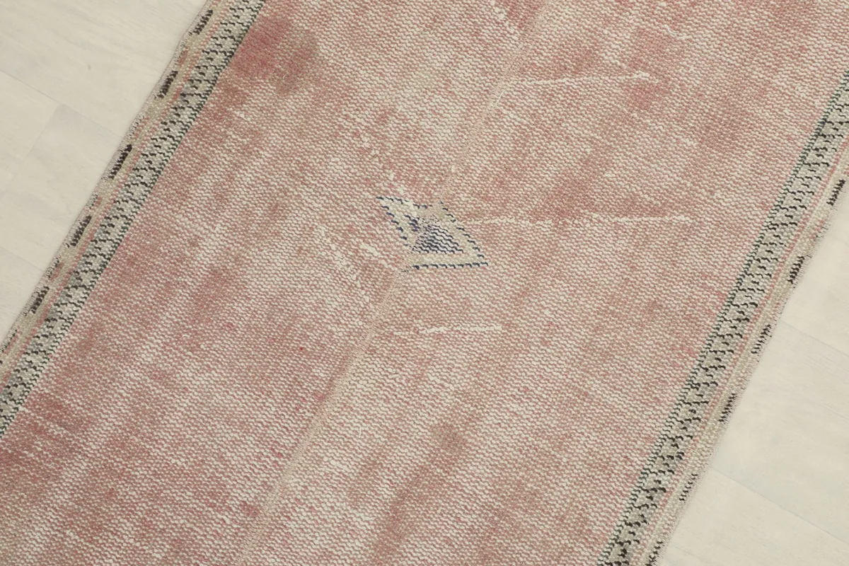 Close-up detail of the central geometric motif and the subtle color variations in the rose pile