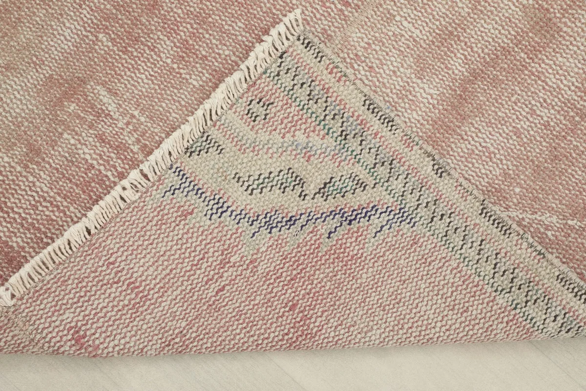 View of the back of the rug, revealing the intricate hand-knotted cotton foundation
