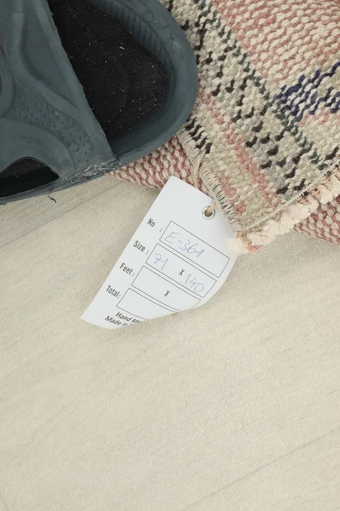 Close-up of the size tag (71 x 141 cm) attached to the corner of the vintage area rug