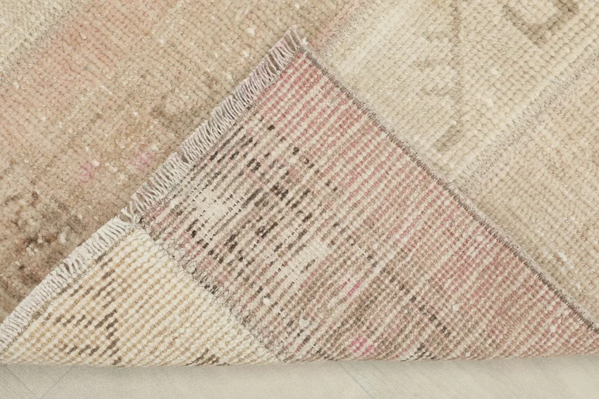 View of the underside of the vintage wool rug, showing the hand-knotted cotton foundation and backing