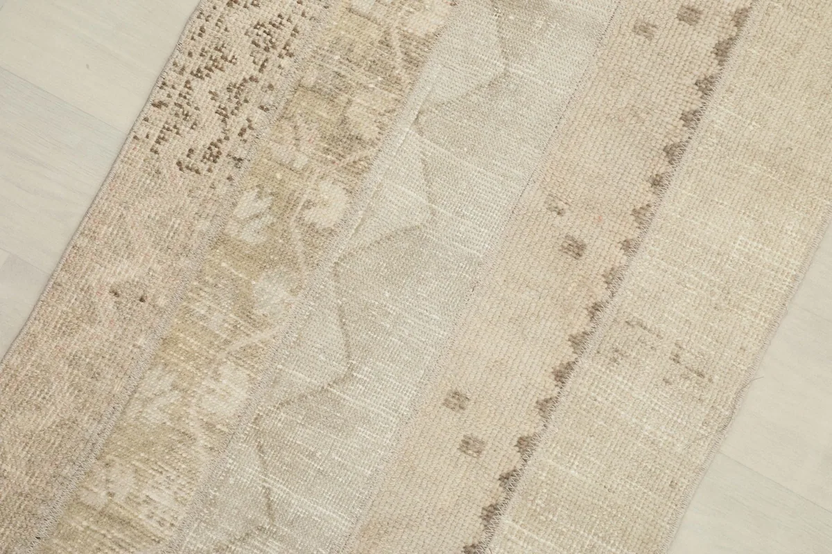Close-up detail of the rug's surface, showing faded patterns and textures within the patchwork