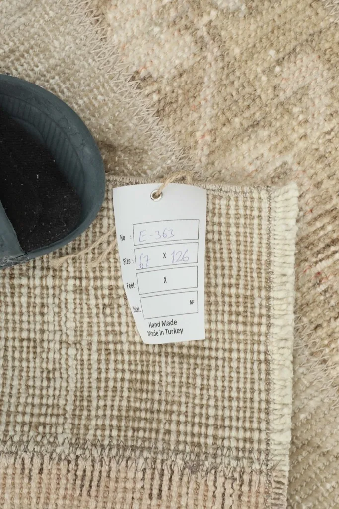 Close-up of the rug's back with a product tag, confirming its hand-made origin in Turkey