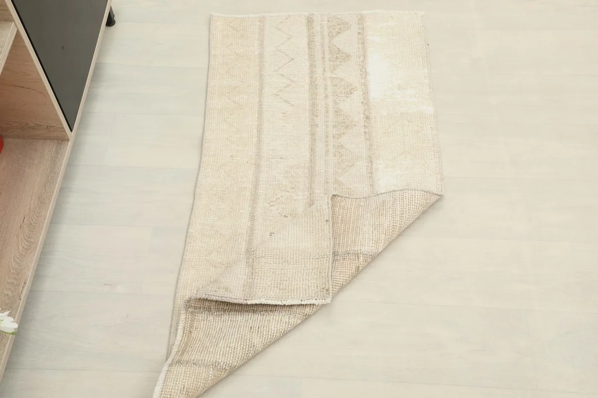Rug partially folded, displaying its flexibility and the texture of the wool pile