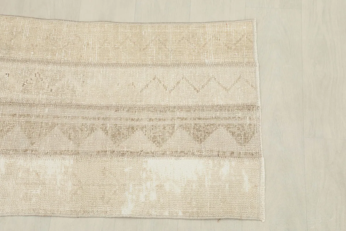Overhead shot of the rug's center and one end, showing the linear geometric patterns