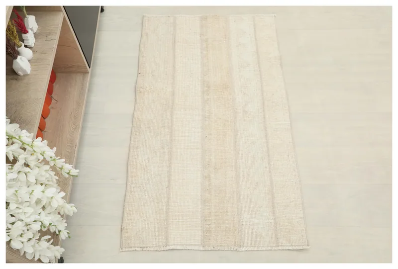 Full overhead view of the beige and ivory vintage Anatolian area rug on a light floor.