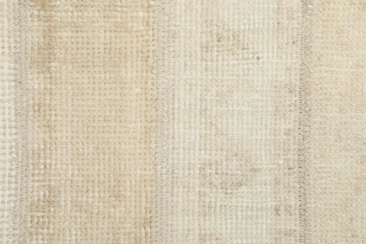 Detailed view of the hand-knotted wool pile and subtle color shifts across the rug's surface.