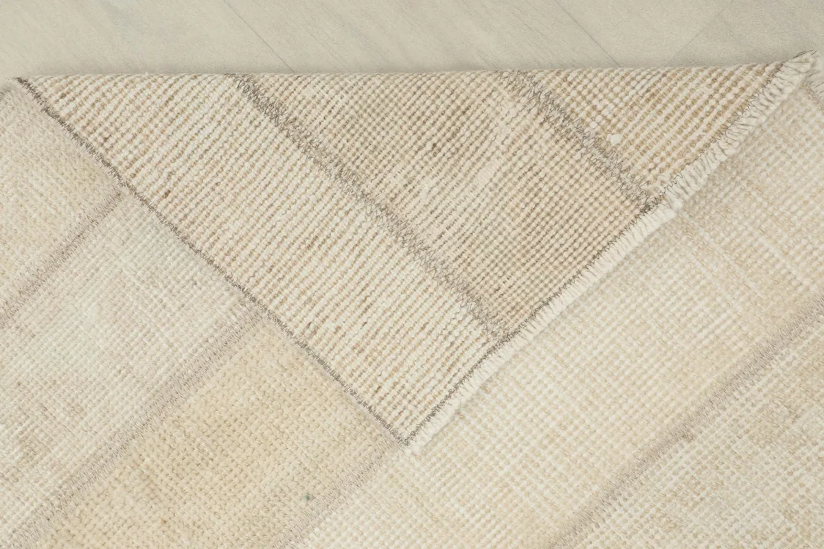 View of the rug's back, revealing the cotton foundation and hand-knotted construction.