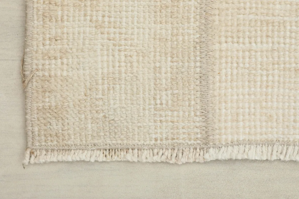 Close-up of the rug's edge, showing the short, natural fringe and tight weave.