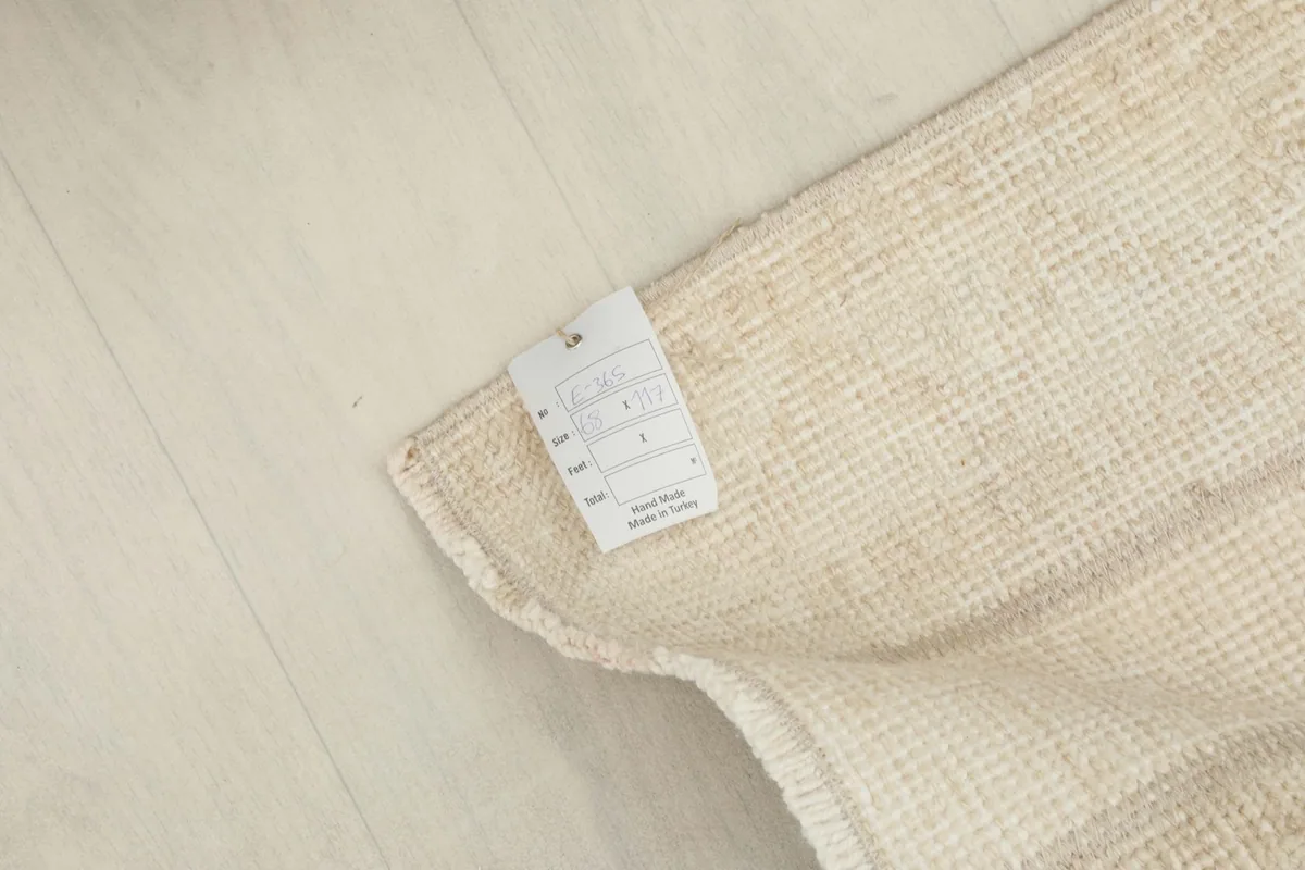 Corner of the rug with a label, indicating origin and material details.