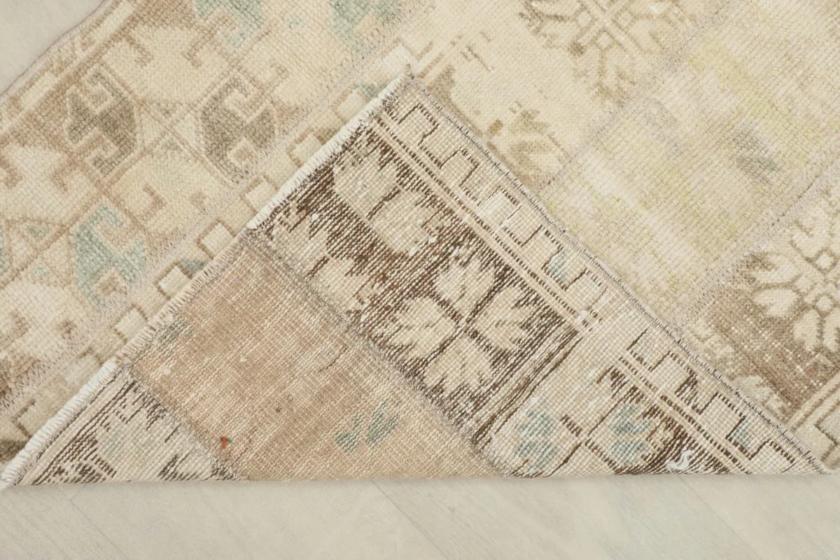 Corner of the rug folded back, revealing the cotton foundation and hand-knotted construction