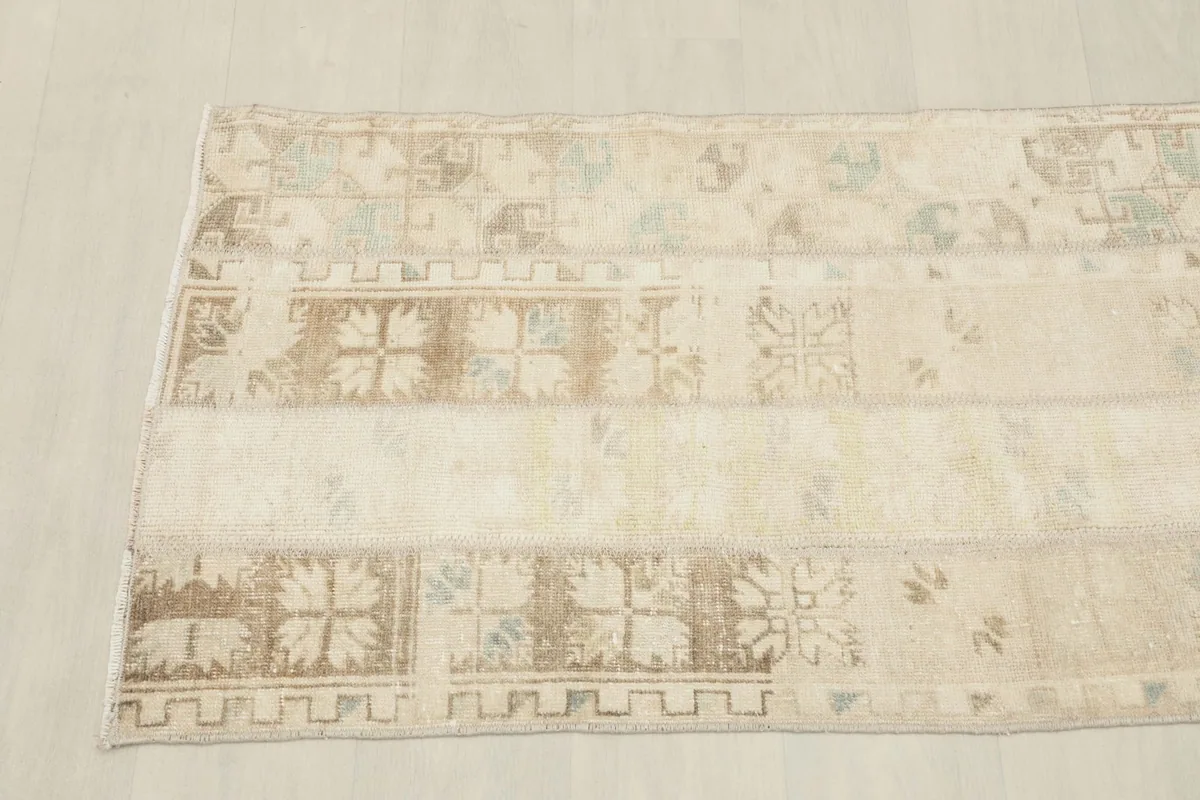 Overhead shot of one end of the vintage rug, showing the blend of patterned patches