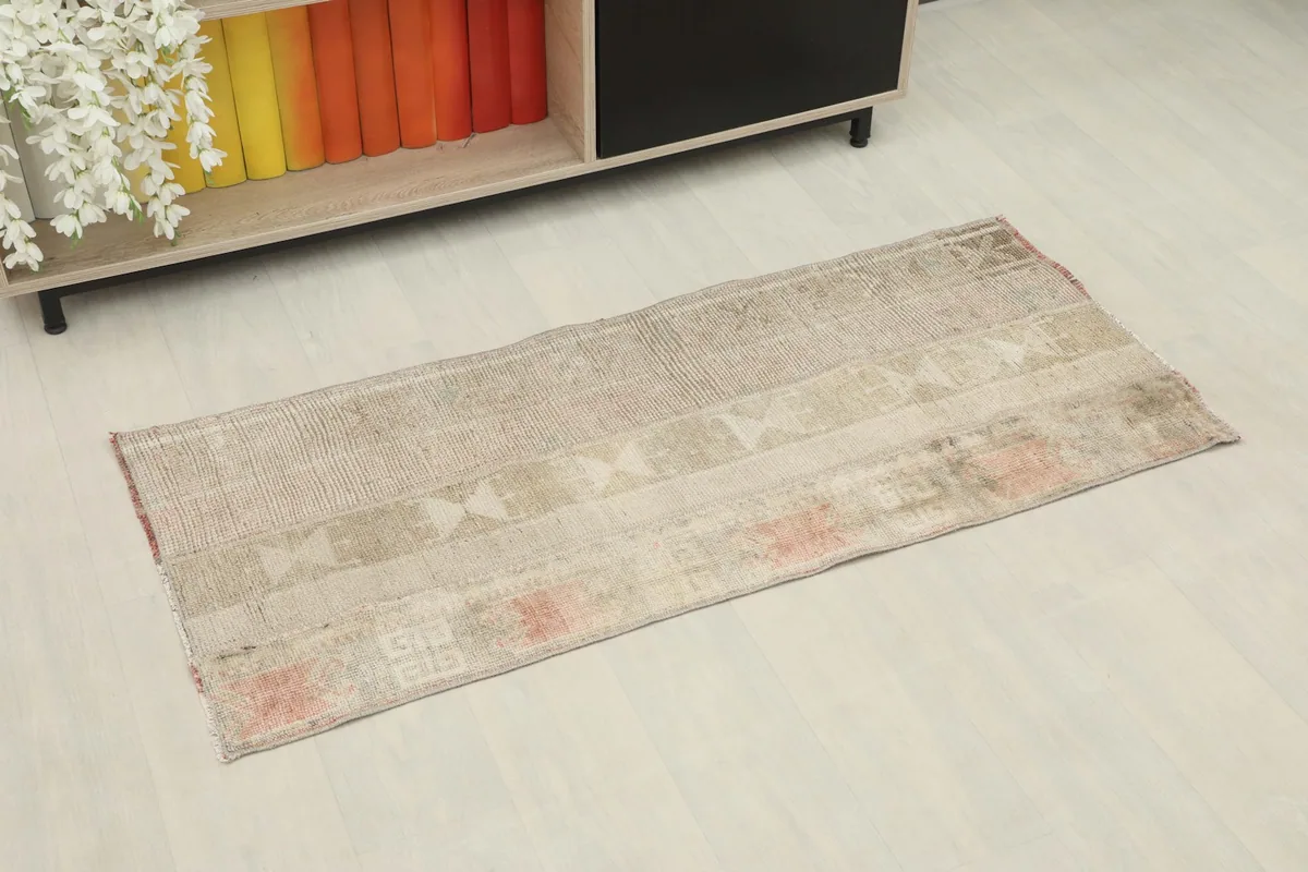 Angled view of the vintage Anatolian rug, showing its rectangular shape and muted color palette.