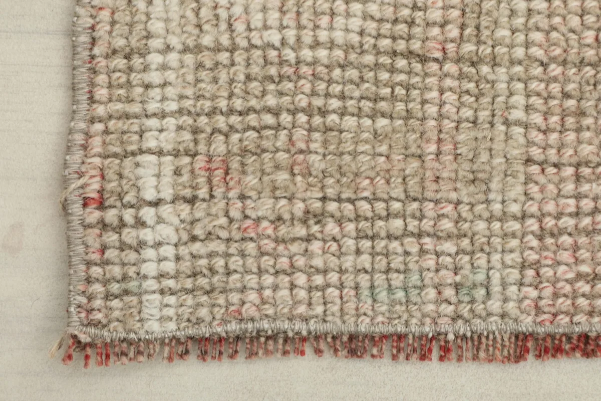 Close-up of the low wool pile and the short fringe along one edge of the vintage rug.