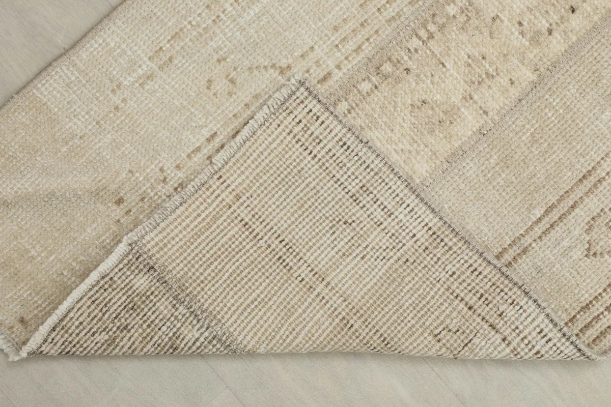 View of the back of the rug, showing the cotton foundation and knotting
