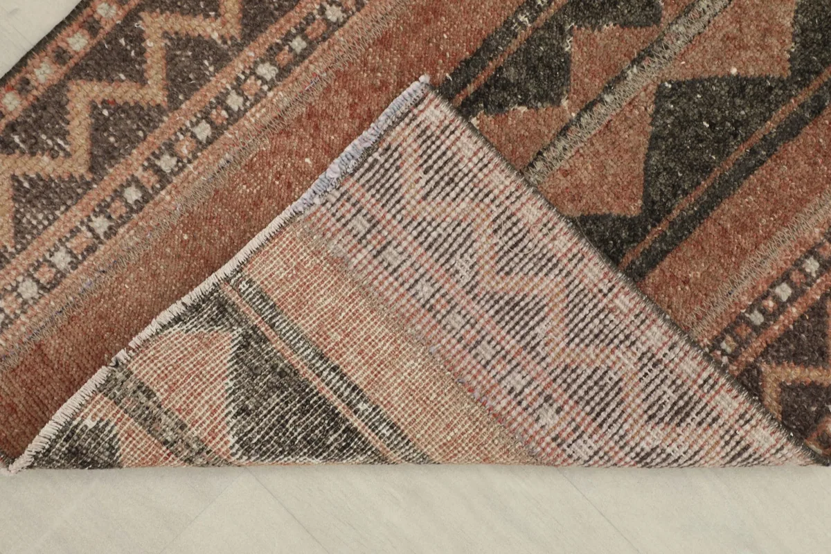 View of the back of the hand-knotted rug, revealing the cotton foundation and knot structure.