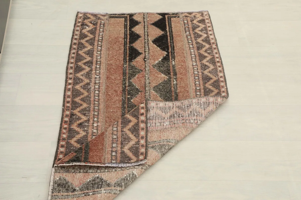 The vintage rug folded to show its flexibility and overall pattern from an elevated perspective.