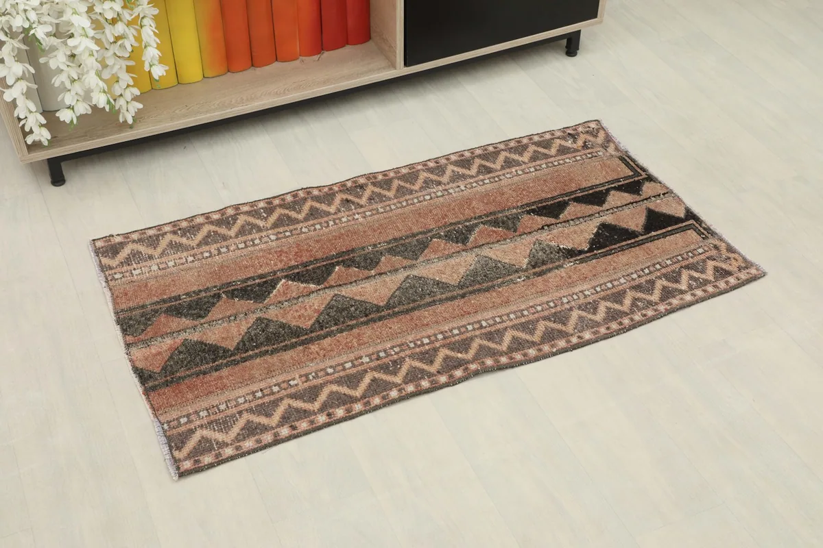 Overhead angle view of the hand-knotted vintage rug with tribal patterns and a subtle patina.
