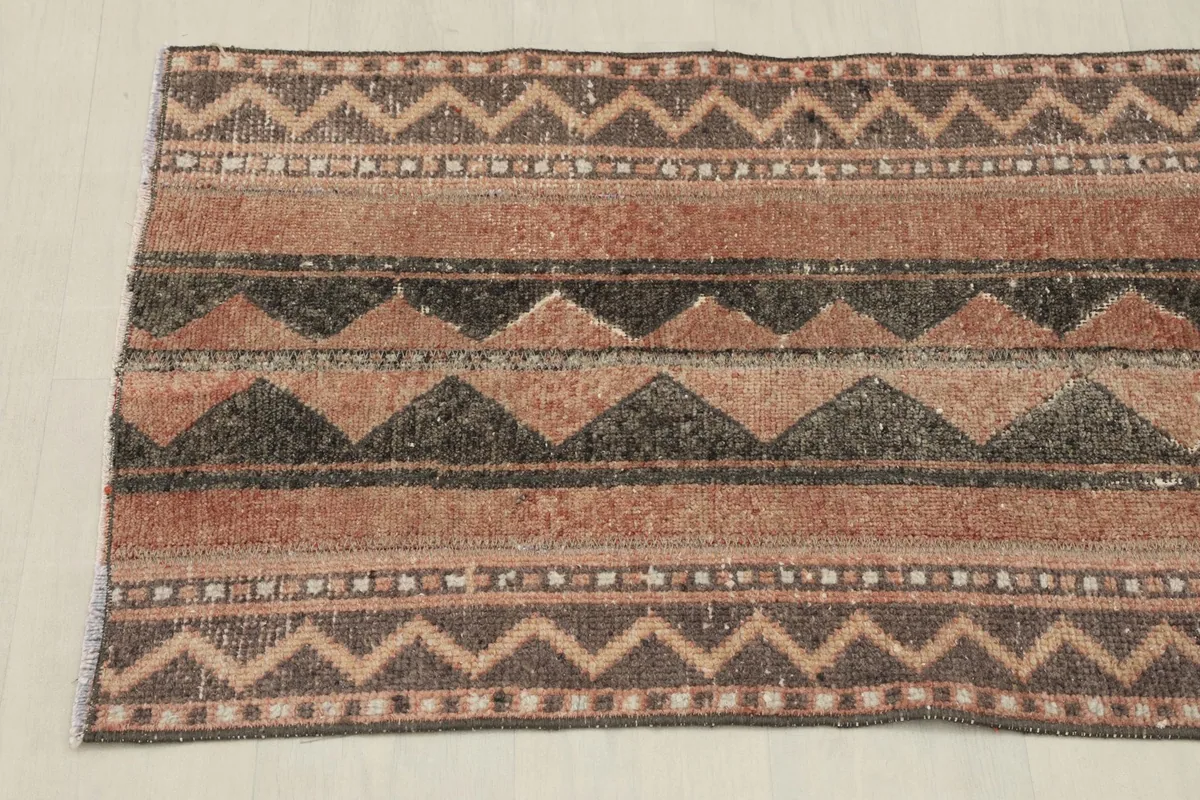 Top-down view of one end of the rug, displaying the horizontal striped and zigzag patterns.