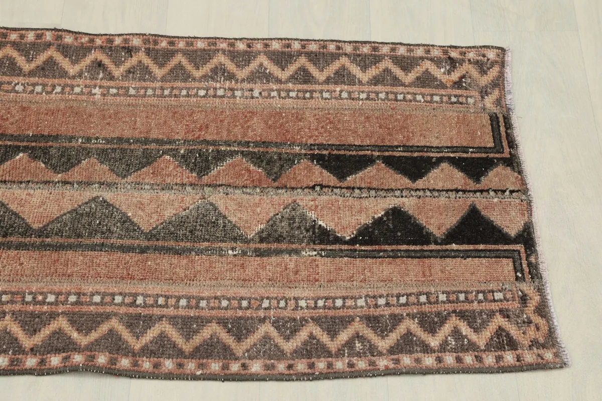 Top-down view of the other end of the rug, showing the consistent geometric border design.