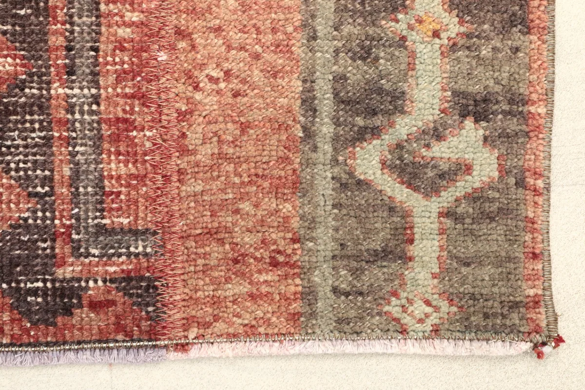 Close-up detail of the rug's edge, showing the rust and gray colors and texture