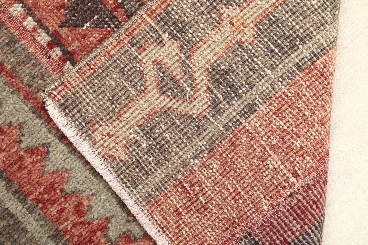 View of the rug's reverse side and folded corner, showing the cotton foundation