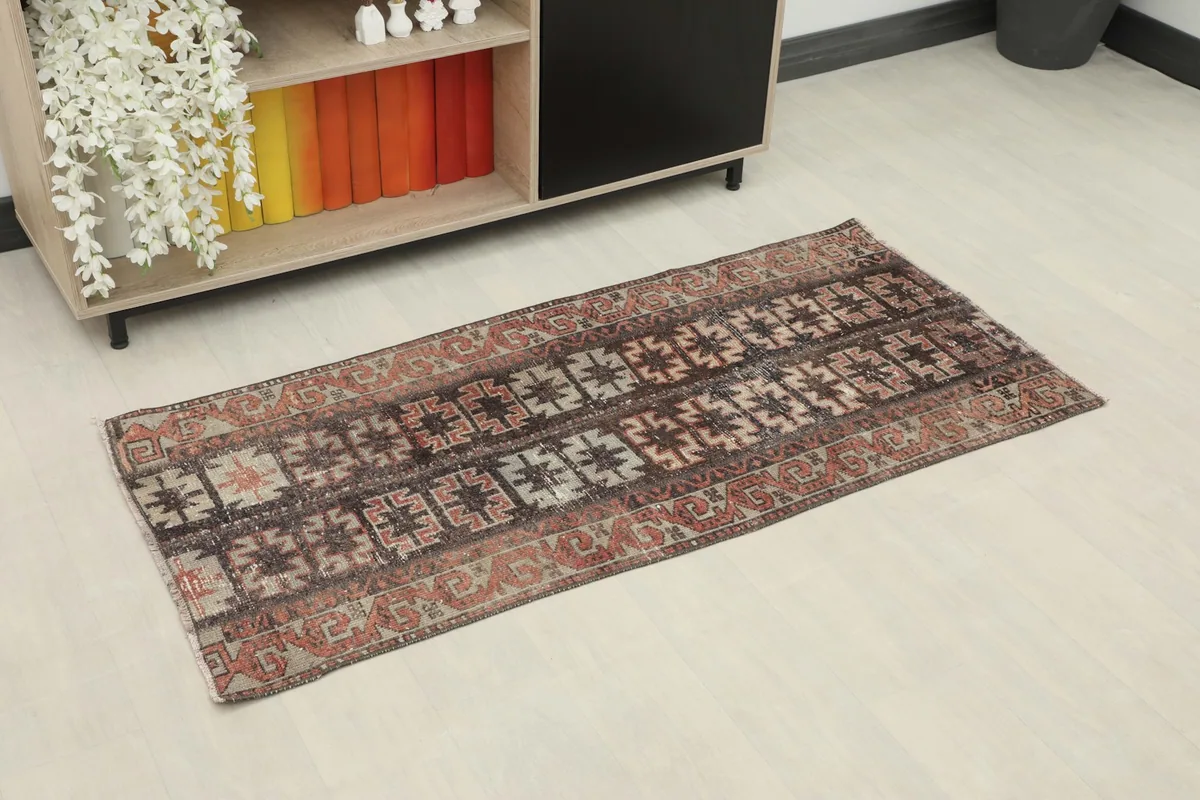 Vintage Anatolian rug displayed in a room setting, showcasing its black and rust colors