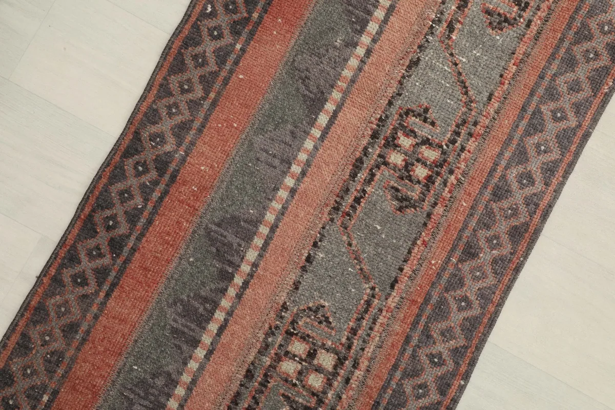 Angled view of the rug, highlighting the striped design and texture of the wool pile.