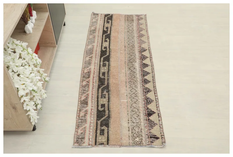 Full overhead view of the beige, rose, and charcoal striped vintage Anatolian runner rug on a white background.