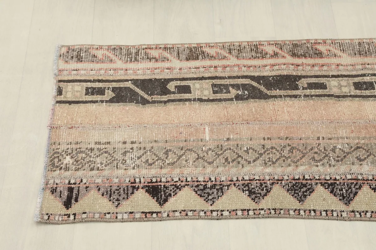 Detailed view of the varied geometric and tribal patterns across the width of the vintage runner.