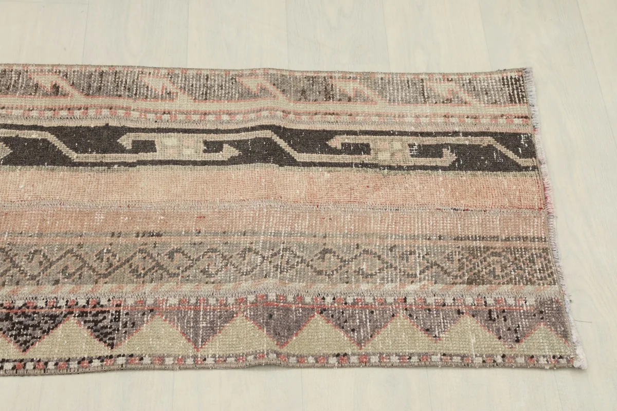 Another detailed perspective of the rug's patterns and colors, focusing on the texture and slight wear.
