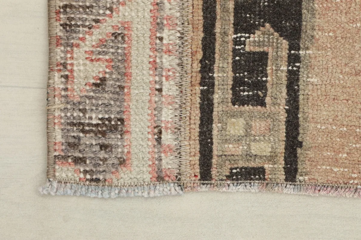 Close-up of the end of the runner rug, showing the low pile and subtle fringe details.