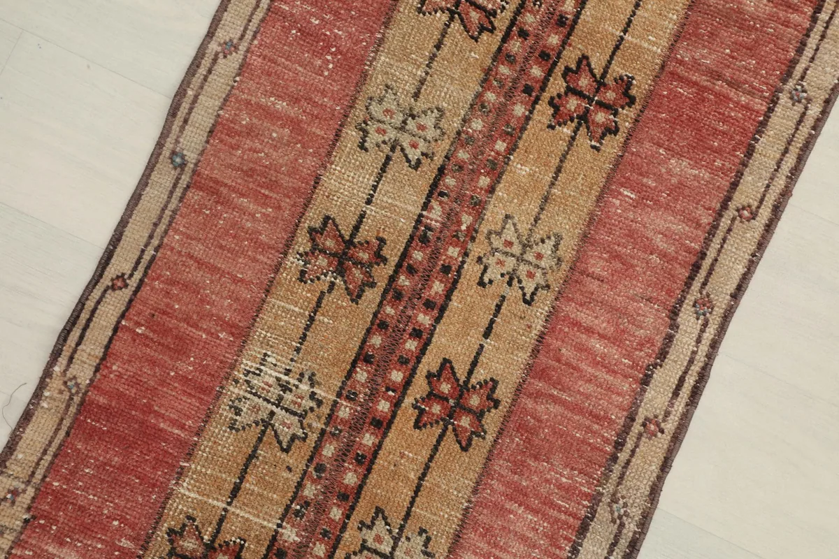 Close-up detail of the red and tan field with geometric tribal motifs