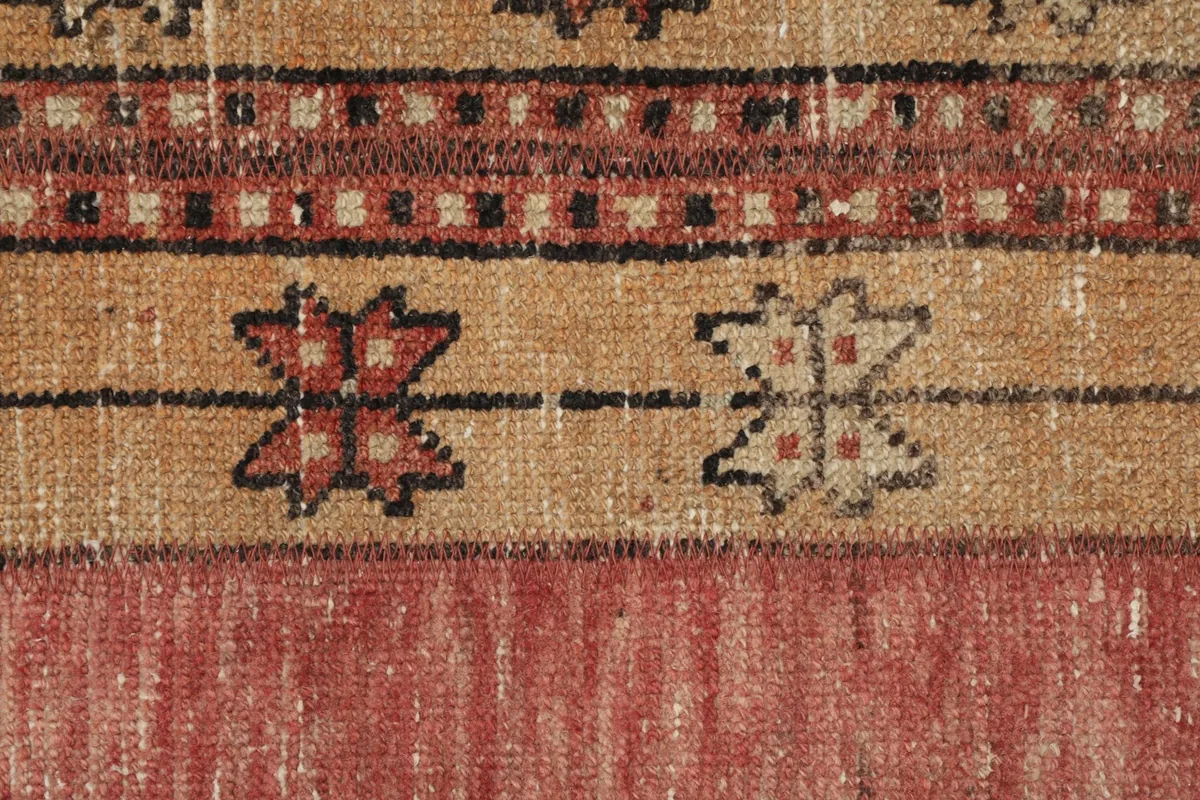Close-up of the geometric patterns and color variations in the rug's pile