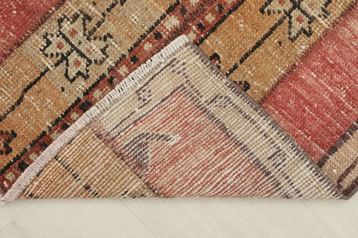 View of the rug's underside and folded corner, revealing the cotton foundation