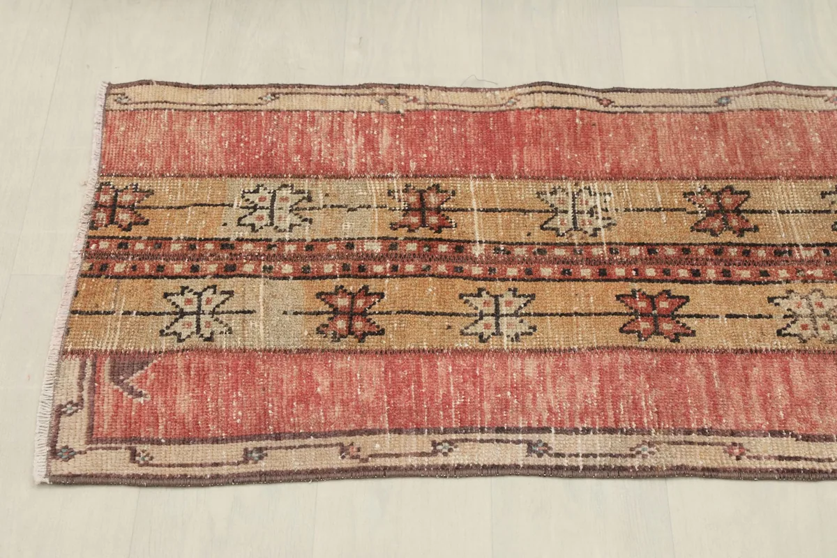 Overhead view showing the length and symmetrical pattern of the red and tan rug