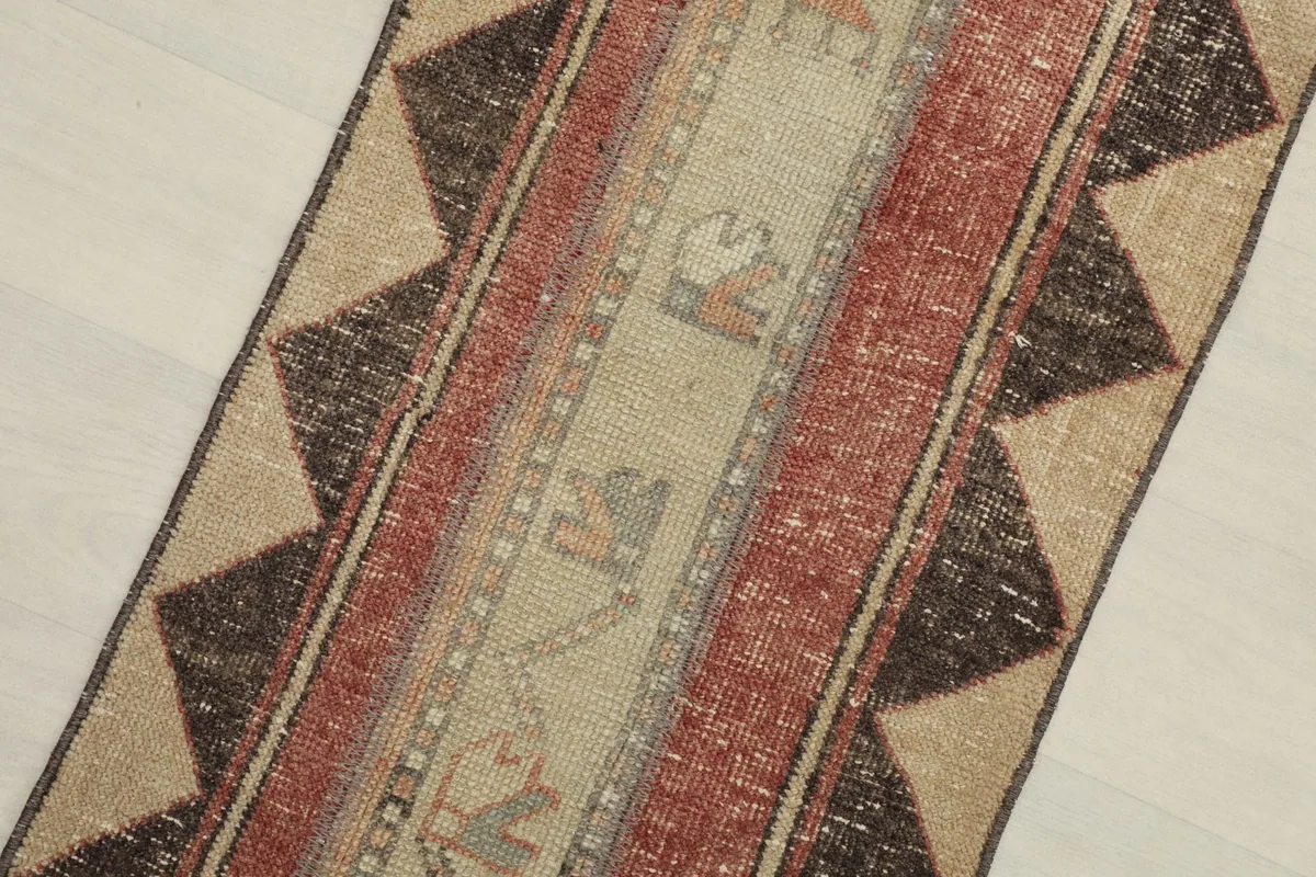 Close-up overhead view of the runner's central design, highlighting beige, rust, and charcoal colors.