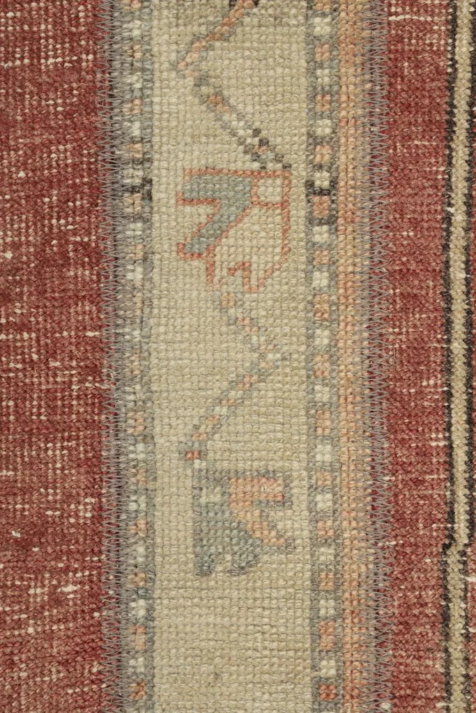 Detailed view of the central beige stripe with tribal motifs and surrounding rust sections.