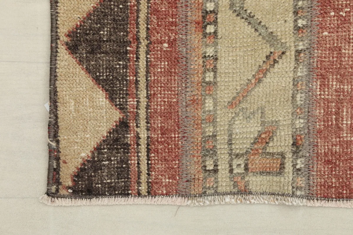 Corner detail of the runner showing the geometric border and fringe.