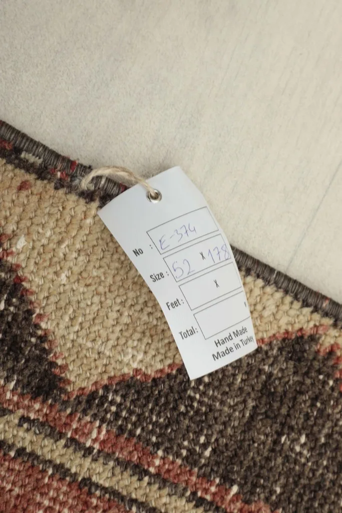 Close-up of the rug's tag, confirming its hand-knotted origin and size.